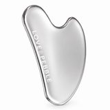 A polished silver gua sha facial scraping tool with the brand name 'LOVE & PEBBLE' engraved vertically on its smooth, curved surface, set against a clean white background.