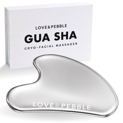 A silver heart-shaped gua sha cryo-facial massager with a white branded box behind it on a clean white background.